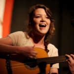 Un campeggiatore si esibisce con la chitarra Camp Eagle Hill