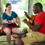 Dei campeggiatori del Camp Eagle Hill a lezione di chitarra