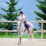 Una campeggiatrice dell'Altitude Summer Camp va a cavallo