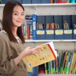 Una studentessa della scuola International House Newcastle in biblioteca