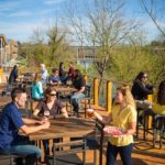 Gustando una birra al New Belgium Brewery sulla banchina del fiume French Broad, Asheville, Carolina del Nord.