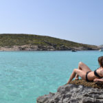Una studentessa della ESE Malta prende il sole a Comino