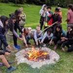 Gli studenti del Campo Estivo Les Elfes arrostiscono i marshmallow sul fuoco