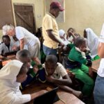 Recoding Africa cofounder and other volunteers helping familiarize Kwetu School students with the Cisco platform