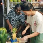 Volunteer helping a community member in her fruit store