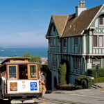 A cable car passes a characteristic San Francisco house
