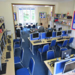 Students in the computer room at CES Leeds with teacher assistance