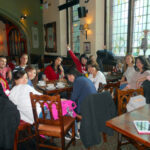 Excel English students at the Coffee and Conversation gathering with a teacher