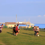 ELC Brighton students play football on the lawn in Hove