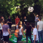 Excel English students play a giant "board" game in the garden
