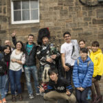 CES Edinburgh students with bagpipe player
