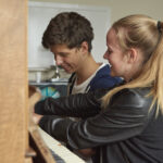 Earlscliffe students play piano in one of the common rooms